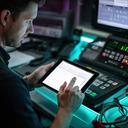 Fleet manager checking route updates on a tablet beside a dispatch console
